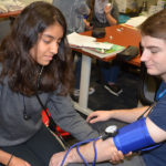 CNA student taking blood pressure.